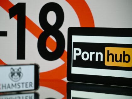 This photograph taken in Toulouse, southern France, shows screens displaying an age restriction warning sign and the logos of the pornographic sites Pornhub (R) and Xhamster (L), on May 24, 2022. - The judicial examination of Arcom request against porn sites has been postponed to one month, on May 24, …