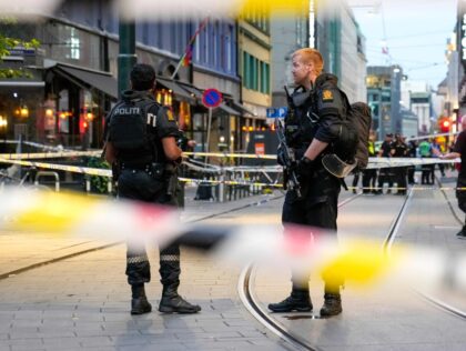 Norwegian police officers stand guard in the streets of central Oslo between security tape lines, on June 25, 2022, after shots were fired outside the London pub, killing two people. - Police said a suspect had been arrested following the shootings, which occurred around 1:00 am (2300 GMT Friday) in …