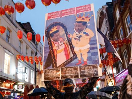 LONDON, UNITED KINGDOM - 2022/10/23: A protester holding a placard that says "Say no to China" arrives at China Town during an anti-Chinese Communist Party assembly in London. Hundreds of people marched under a rain storm from Downing Street via Chinatown to the Chinese Embassy in London to protest against …