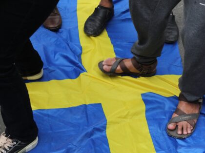 Activists step on the Swedish flag as demonstrators gather outside the Swedish Embassy in Jakarta on January 30, 2023, as they protest against the burning of the Koran in Sweden. - Protests have erupted across the Muslim world after Swedish-Danish far-right politician Rasmus Paludan set fire to a copy of …