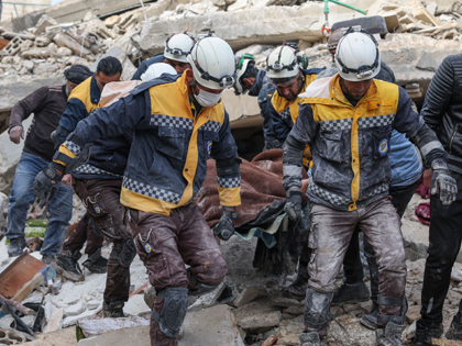 Members of the Syrian civil defence, known as the White Helmets, transport a casualty from the rubble of buildings in the village of Azmarin in Syria's rebel-held northwestern Idlib province at the border with Turkey following an earthquake, on February 7, 2023. (Photo by Omar HAJ KADOUR / AFP) (Photo …