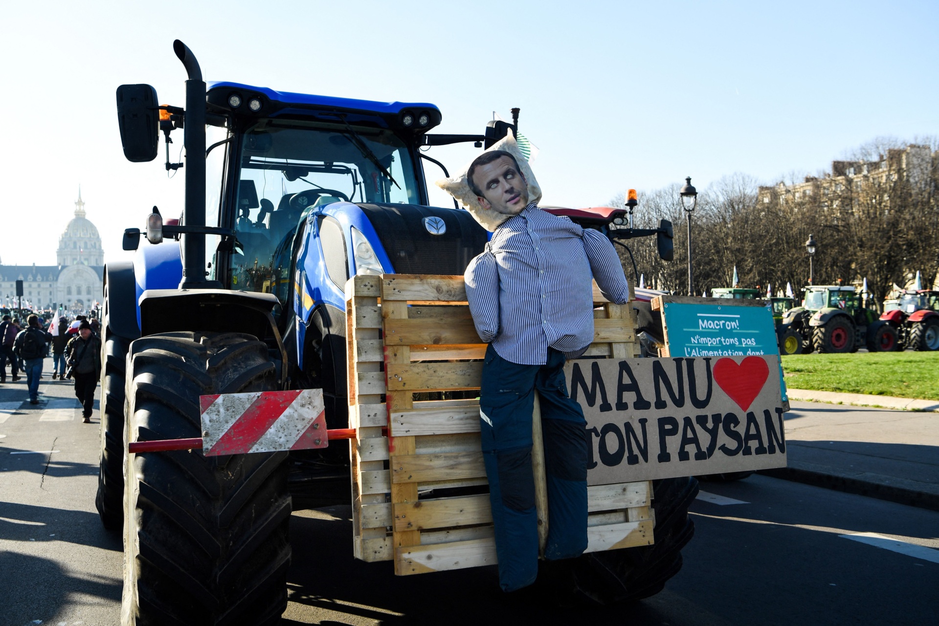 This photograph shows a dummy representing French President Emmanuel Macron with a sign reading "Manu, loves your peasant" on a tractor at the Esplanades des Invalides during a demonstration organised by unions including FNSEA (National Federation of Farmers Union), against "obligations" in agriculture, in particular restrictions on the use of pesticides, in Paris, on February 8, 2023. (Photo by Bertrand GUAY / AFP) (Photo by BERTRAND GUAY/AFP via Getty Images)