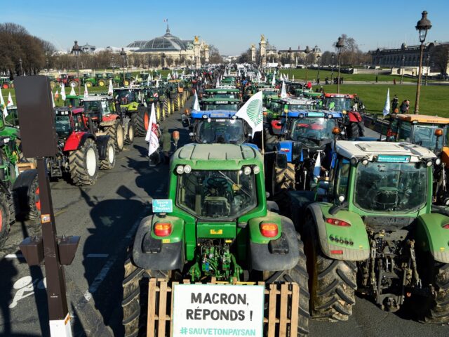 This photograph shows a sign reading "Macron, anwers !" as farmers stand next to tractors at the Esplanades des Invalides during a demonstration organised by unions including FNSEA (National Federation of Farmers Union), against "obligations" in agriculture, in particular restrictions on the use of pesticides, in Paris, on February 8, …