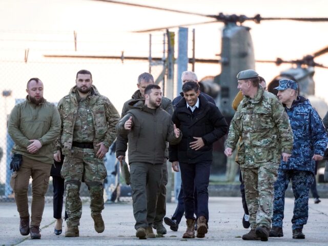 TOPSHOT - Ukraine's President Volodymyr Zelensky (C-L) and Britain's Prime Minister Rishi Sunak (C-R) arrive to meet Ukrainian troops being trained to command Challenger 2 tanks at a military facility in Lulworth, Dorset in southern England on February 8, 2023. - Zelensky used a visit to London to urge allies …