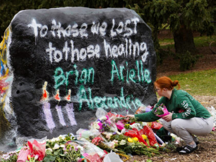 Lansing, MI-February 15, 2023: A student places her bouquets of flowers at the University two days after a shooting at Michigan State University in East Lansing, Michigan on February 15, 2023. (Photo by Dieu-Nalio Chery for The Washington Post via Getty Images)