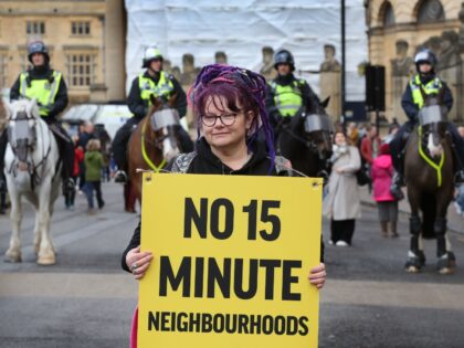 OXFORD, ENGLAND - FEBRUARY 18: A protester holds a sign saying No 15-Minute Neighbourhoods as protesters gather in Broad Street watched by police on horseback on February 18, 2023 in Oxford, England. The concept of 15-minute cities suggest that all services , amenities, work and leisure are accessible a 15-20 …