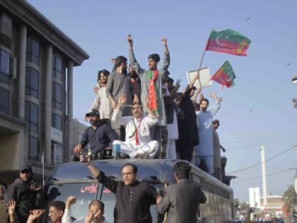 Supporters of former Pakistani Prime Minister Imran Khan are seen on the rooftop of police