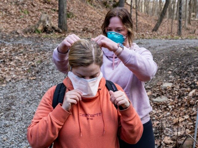 Olivia Holley, 22, and Taylor Gulish, 22, put PPE on before collecting water samples from