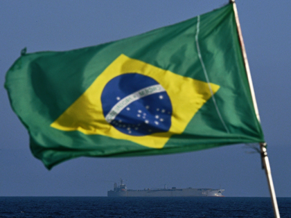A Brazilian flag waves while the Iranian warship IRIS Makran sails on the coast of Rio de
