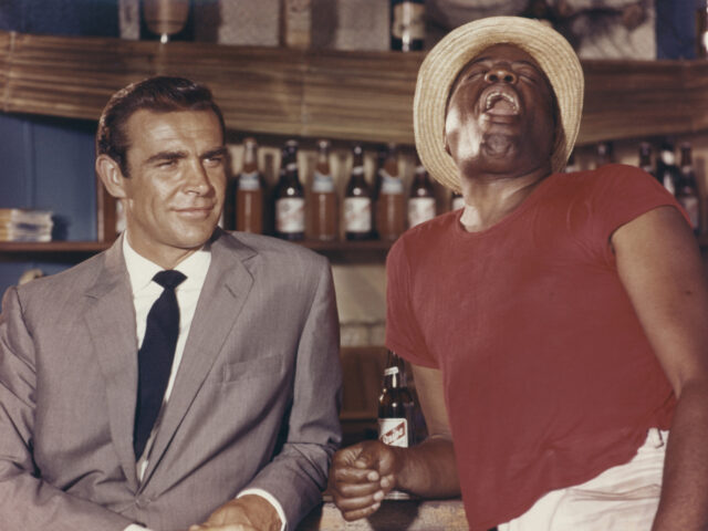 'Dr No' 1962 Sean Connery as James Bond 007 with John Kitzmiller as Quarrel standing by bar in the Bahamas. (Photo by Screen Archives/Getty Images)