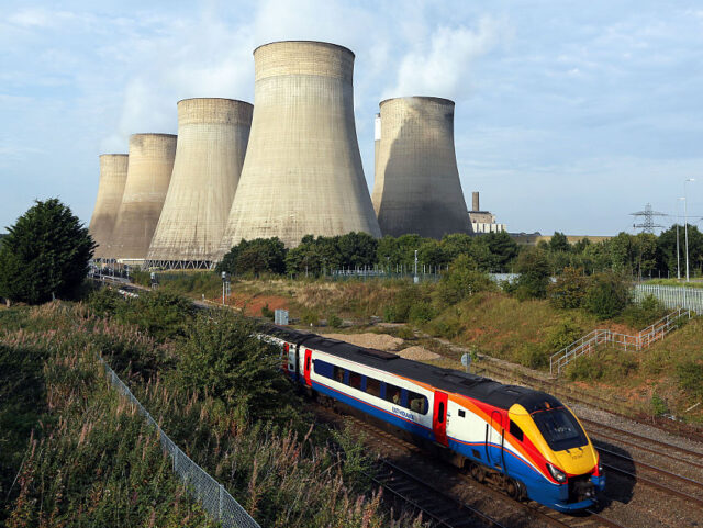 An East Midlands train service travels beneath the cooling towers at Uniper SE's coal-fired power station in Ratcliffe-on-Soar, U.K., on Tuesday, Sept. 13, 2016. EON SE cut most of the grip on the utility's legacy fossil-fuel fired power stations as its Uniper SE unit was listed on Monday. Photographer: Chris …