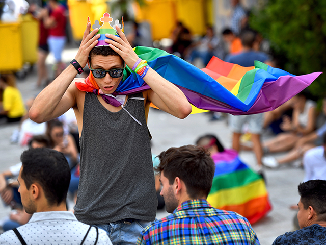 A boy adjusts a paper crown with the rainbow colours in Madrid's Chueca district on J