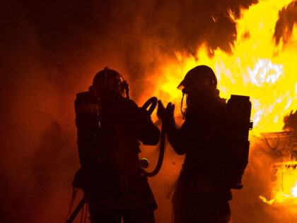 View of a Firefighters Holding a Fire Hose Putting Out a Fire