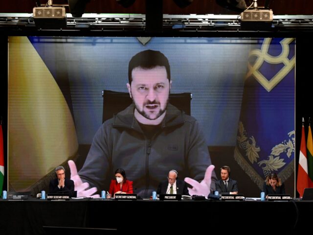 krainian President Volodymyr Zelensky is seen on a giant screen as he delivers a speech du
