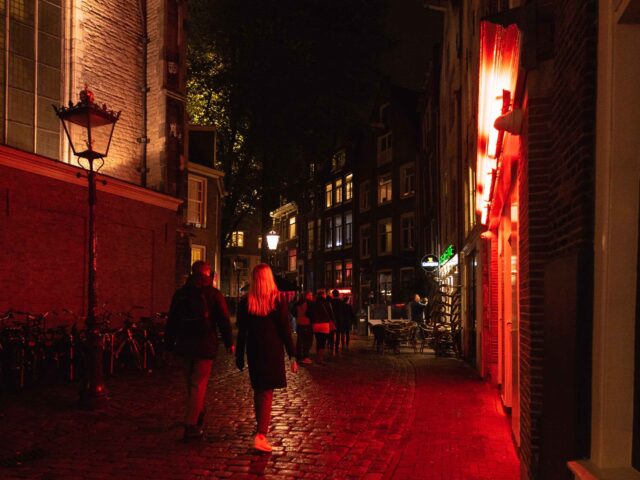 People walking on street in red light district at night, Amsterdam, Netherlands (Getty)