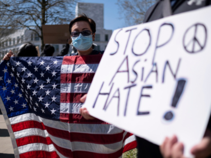Lucy Lee, of Marietta, Ga., holds an American flag while rallying outside of the Georgia State Capitol in Atlanta during a unity "Stop Asian Hate" rally Saturday afternoon, March 20, 2021. (AP Photo/Ben Gray)