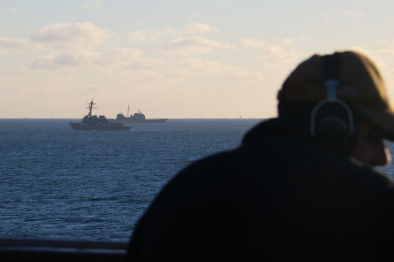 Seaman Rafael Mendez stands watch aboard the USS Carter Hall while the guided-missile destroyer USS Oscar Austin and the guided-missile cruiser USS Philippine Sea transit alongside debris from a Chinese high-altitude surveillance balloon. Photo by Lt. J.G. Jerry Ireland/U.S. Navy/UPI | L
