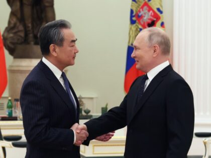 Russian President Vladimir Putin shakes hands with Chinese Communist Party's foreign policy chief Wang Yi during their meeting at the Kremlin in Moscow, Russia, Wednesday, Feb. 22, 2023. (Anton Novoderezhkin, Sputnik, Kremlin Pool Photo via AP)