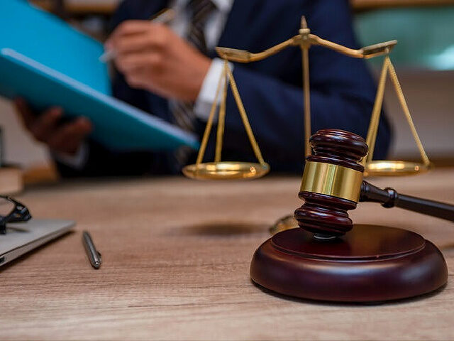 Male lawyer working with contract papers and wooden gavel on tabel in courtroom. justice and law ,attorney, court judge, concept. - stock photo