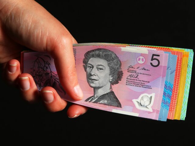 A person holds Australian dollar banknotes of various denominations for a photograph in Sy