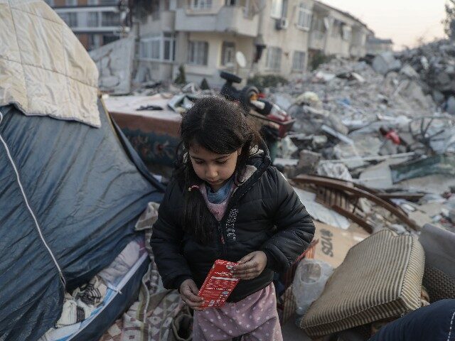 A girl walks near a tent beside collapsed buildings on February 13, 2023 in Hatay, Turkey. A 7.8-magnitude earthquake hit near Gaziantep, Turkey, in the early hours of Monday, followed by another 7.5-magnitude tremor just after midday. The quakes caused widespread destruction in southern Turkey and northern Syria and were …