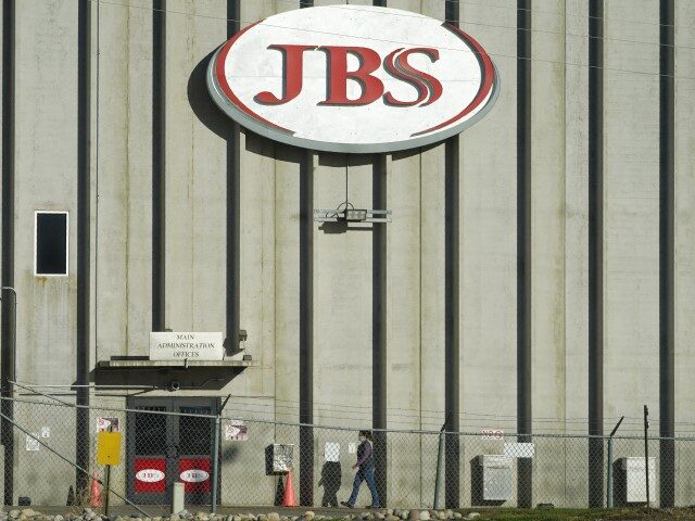 FILE - A worker heads into the JBS meatpacking plant in Greeley, Colo., on Oct. 12, 2020. Packers Sanitation Services Inc., or PSSI, one of the country's largest food safety cleaning service providers employed more than 100 children as young as 13 in dangerous jobs at 13 meat processing plants …