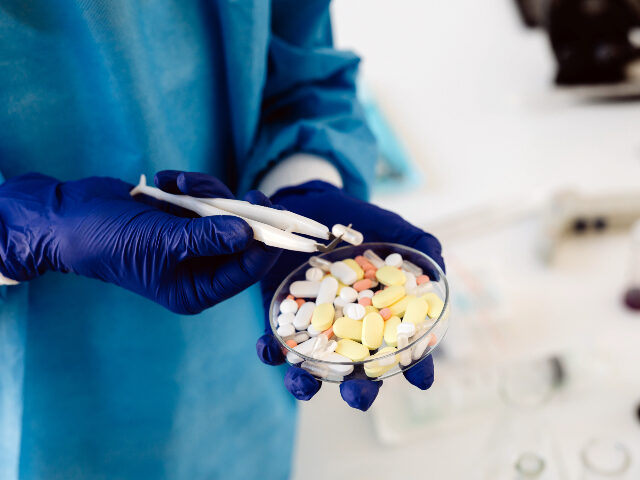 Person Holding a Petri Dish with Assorted Pills