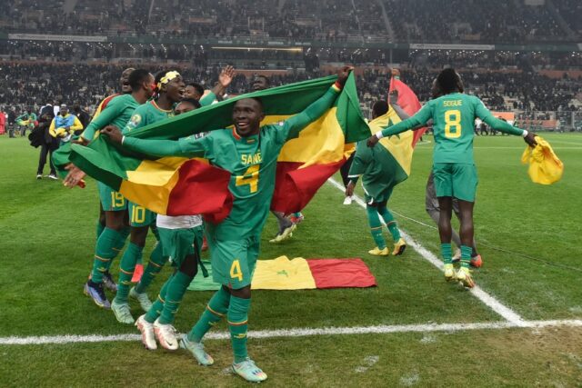 Final flourish: Senegal defender Mamadou Sane celebrates with the national flag after Satu