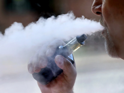 In this Saturday, June 8, 2019, file photo, two women smoke cannabis vape pens at a party in Los Angeles. On Thursday, Dec. 12, 2019, U.S. health officials said 26 states have reported deaths, for a total of 52. (AP Photo/Richard Vogel, File)