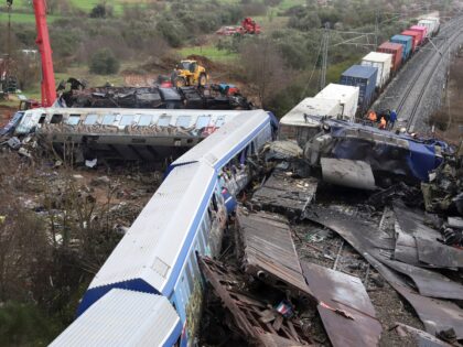 A crane, firefighters and rescuers operate after a collision in Tempe, about 376 kilometres (235 miles) north of Athens, near Larissa city, Greece, Wednesday, March 1, 2023. A train carrying hundreds of passengers has collided with an oncoming freight train in northern Greece, killing and injuring dozens passengers. (AP Photo/Vaggelis …