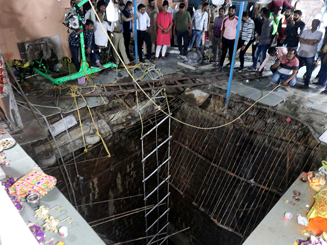 People stand around a structure built over an old temple well that collapsed Thursday as a large crowd of devotees gathered for the Ram Navami Hindu festival in Indore, India, Thursday, March 30, 2023. Up to 35 people fell into the well in the temple complex when the structure collapsed …