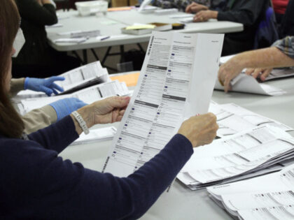 FILE - An election worker examines a ballot at the Clackamas County Elections office on Th