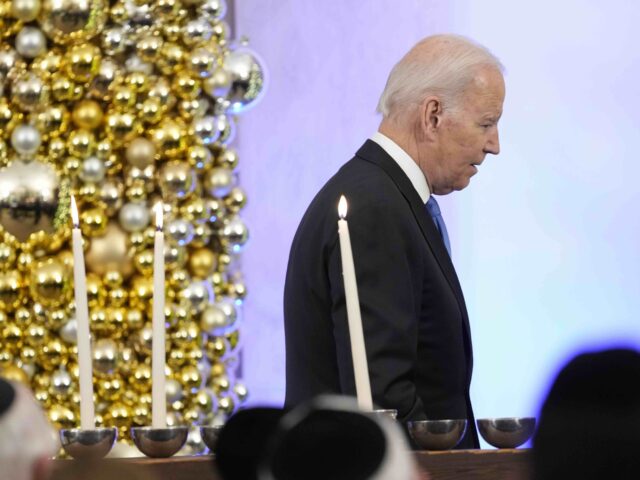 President Joe Biden walks past the White House menorah after speaking during a Hanukkah holiday reception in the Grand Foyer of the White House in Washington, Monday, Dec. 19, 2022. (AP Photo/Susan Walsh)