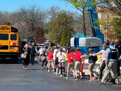 Children from The Covenant School, a private Christian school in Nashville, Tenn., hold hands as they are taken to a reunification site at the Woodmont Baptist Church after a deadly shooting at their school on Monday, March 27, 2023. (AP Photo/Jonathan Mattise)