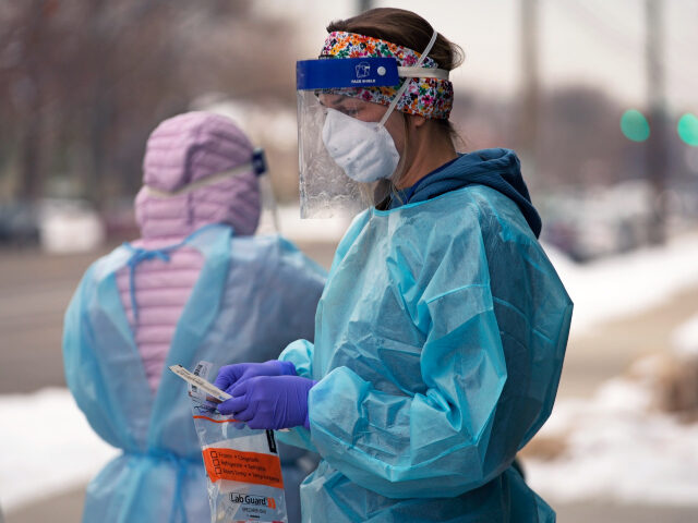 FILE - A nurse prepares for a COVID-19 test outside the Salt Lake County Health Department