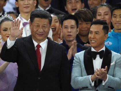 China's President Xi Jinping (C) waves as he stands onstage with Hong Kong performer Lisa Wang (L) and actor Donnie Yen (R) as Xi joins performers at the end of a variety show in Hong Kong on June 30, 2017. China's President Xi Jinping praised Hong Kong for its role …