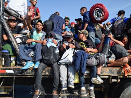 Central American migrants -mostly honduran- taking part in a caravan to the US, get on board a truck heading to Irapuato in the state of Guanajuato on November 11, 2018 after spending the night in Queretaro in central Mexico. - The United States embarked Friday on a policy of automatically …