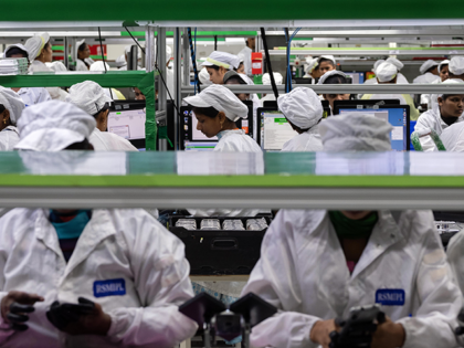 Employees test mobile phones on an assembly line in the mobile phone plant of Rising Stars