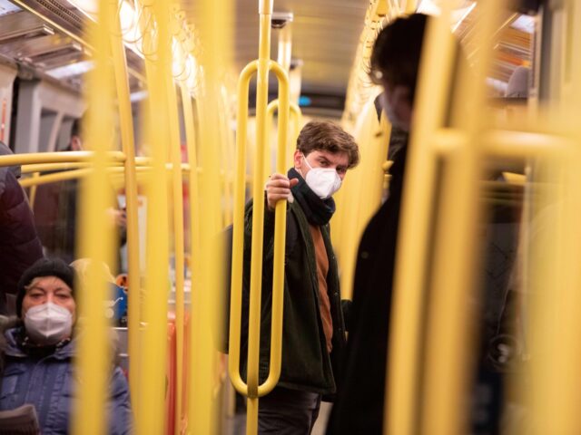 TOPSHOT - A commuter wears an FFP2 protective face mask on a public transport underground