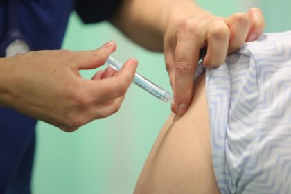 A healthcare professional administers an injection of the Moderna Covid-19 vaccine at a va