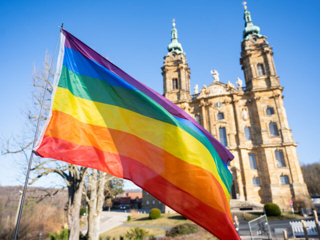 09 March 2022, Bavaria, Bad Staffelstein: A rainbow flag flies in front of the basilica of