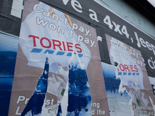 A badly torn protest poster in the city centre that reads "Can't pay, won't pay" over a gr