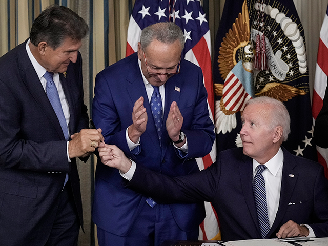 WASHINGTON, DC - AUGUST 16: U.S. President Joe Biden (C) gives Sen. Joe Manchin (D-WV) (L)