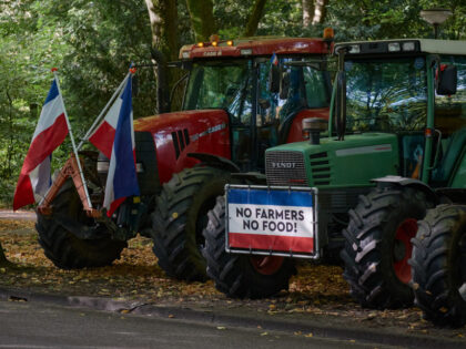THE HAGUE, NETHERLANDS - SEPTEMBER 20: Tractors belonging to Dutch farmers are parked with protest boards and Dutch flags upside down on a road on the outskirt of The Hague on September 20, 2022 in The Hague, Netherlands. Dutch farmers are protesting against the government initiative to reduce nitrogen emissions …