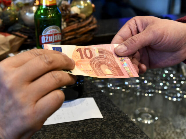 A waiter takes a euro banknote from a customer, in Zagreb, on January 2, 2023. - Since January 1, 2023 the euro is the official currency in Croatia. (Photo by Denis LOVROVIC / AFP) (Photo by DENIS LOVROVIC/AFP via Getty Images)