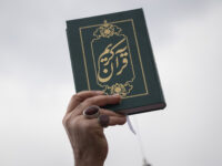 An Iranian cleric holds up a copy of Muslims holy book of Koran while taking part a protest over Koran burning, after Tehran's Friday Prayers ceremonies at the Imam Khomeini Grand mosque, January 27, 2023. Worshippers shout anti-U.S., anti-Israel, and anti-Sweden slogans while taking part a protest over the Koran …