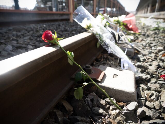 Flowers left by students, laying on the rails of Larissa train station, the last stop of t