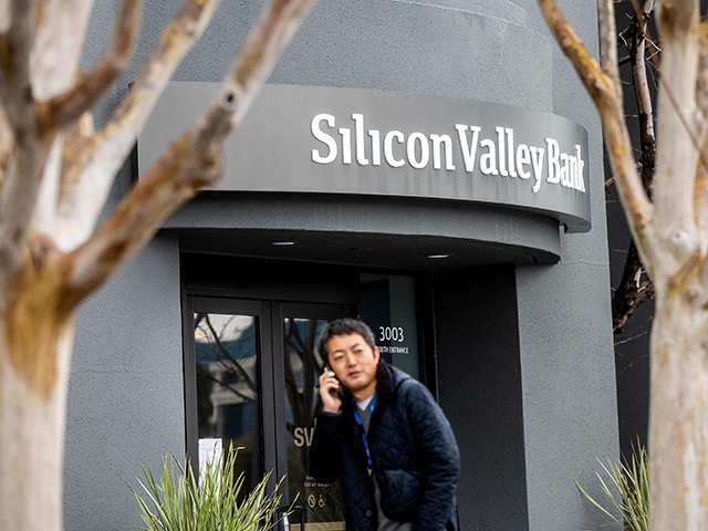 A pedestrian speaks on a mobile telephone as he walks past Silicon Valley Banks headquarters in Santa Clara, California on March 10, 2023. - US authorities swooped in and seized the assets of SVB, a key lender to US startups since the 1980s, after a run on deposits made it no longer tenable for the medium-sized bank to stay afloat on its own. (Photo by NOAH BERGER / AFP) (Photo by NOAH BERGER/AFP via Getty Images)