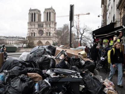 TOPSHOT - This photograph taken in Paris, on March 13, 2023, shows household waste near the Notre-Dame cathedral, that has been piling up on the pavement as waste collectors are on strike since March 6 against the French government's proposed pensions reform. (Photo by ALAIN JOCARD / AFP) (Photo by …