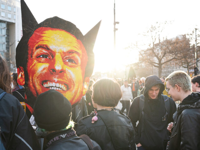 Young demonstrators are grouped around a large caricature of President Emmanuel Macron depicted as a devil during a demonstration to oppose the government's pension reform bill in Paris on March 15, 2023, on the eve of the bill's vote in the national assembly. The demonstration follows a call for strike …